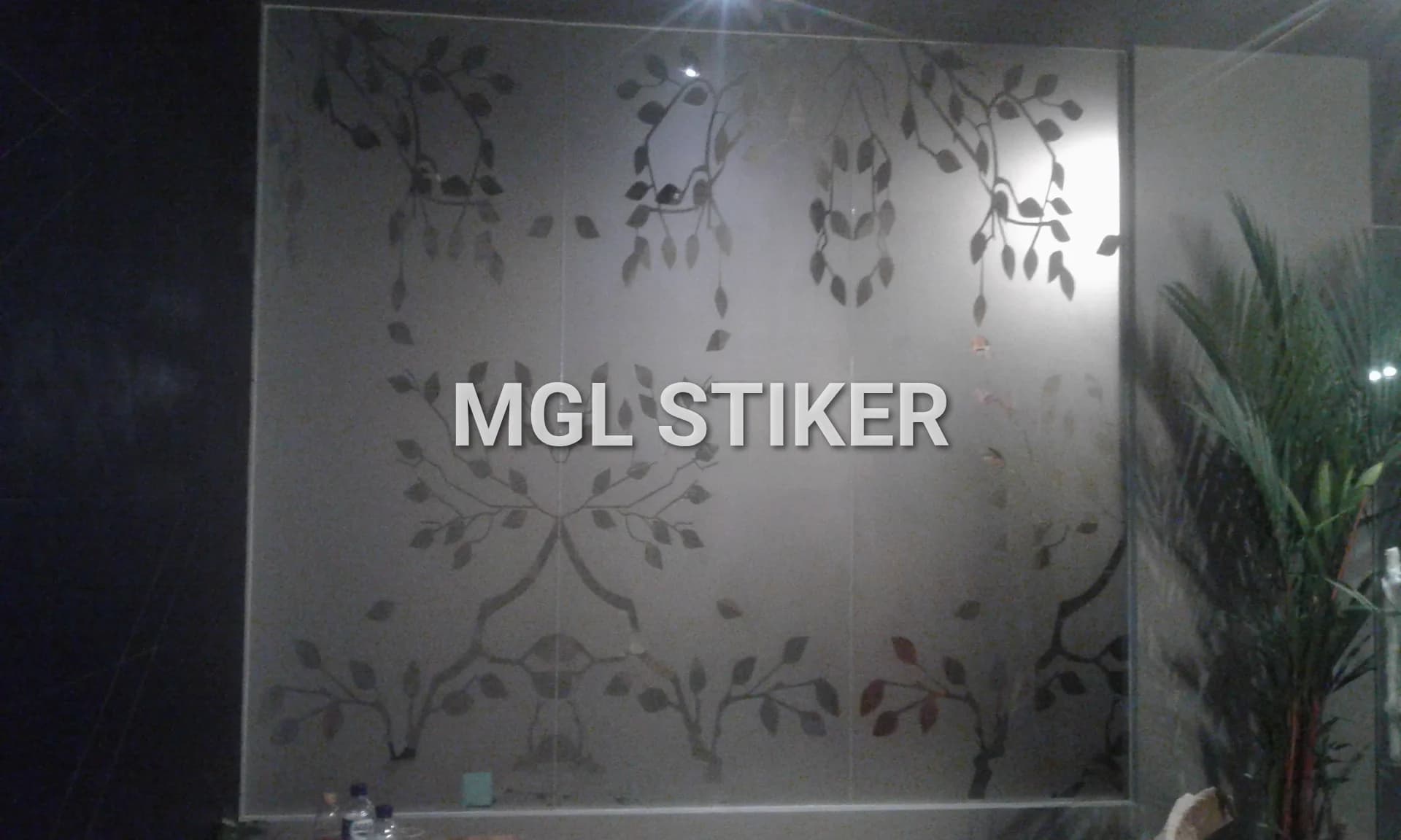 Sticker sandblast dengan motif daun dan ranting pohon yang elegan pada partisi kaca, contoh hasil cutting sticker berkualitas tinggi dari MGL Stiker untuk dekorasi dan privasi ruangan.