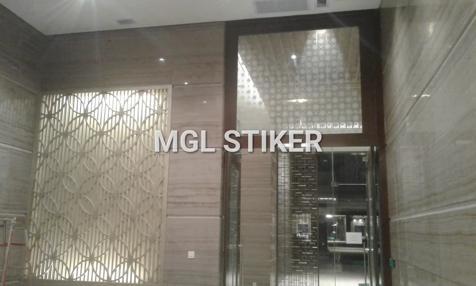 Aplikasi sticker sandblast MGL Stiker pada panel kaca di ruangan modern dengan motif geometris bintang, menunjukkan keunggulan cutting sticker untuk privasi dan estetika interior.